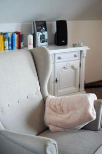 - Silla blanca con almohada en la sala de estar en Ferienwohnung-bei-Familie-Kuehl, en Fehmarn 11 fotos más