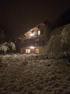 Una casa en la nieve por la noche en Chalet coeur d'alpage La Plagne Les Arcs, en La Plagne Tarentaise