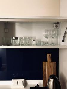 a shelf with wine glasses on top of a counter at Orbi City Hotel D1 Block in Batumi