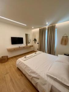 a bedroom with a large white bed and a flat screen tv at Casa del Mar in Vlorë +10 photos