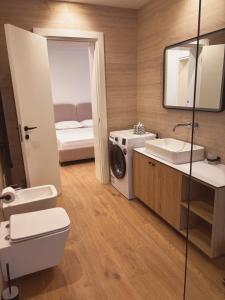 a bathroom with a toilet sink and a washing machine at Casa del Mar in Vlorë