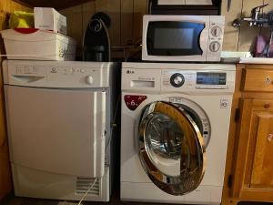 een wasmachine en een magnetron in de keuken bij Nido delle Alpi by SMART-HOME in Pietraporzio