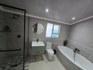 a bathroom with a tub and a toilet and a sink at Tranquil stay and venue in the heart of Ixopo in Ixopo +7 photos