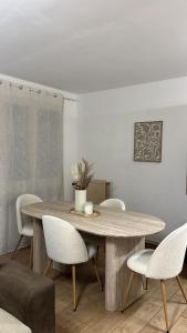 une salle à manger avec une table et des chaises en bois dans l'établissement Appartement moderne à 5min du centre ville et des quais, à Romans-sur-Isère