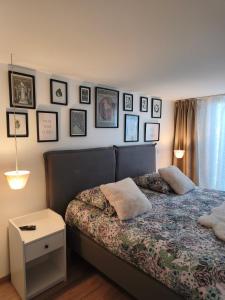 une chambre avec un lit avec des tableaux sur le mur dans l'établissement le stockholm, à Sablons