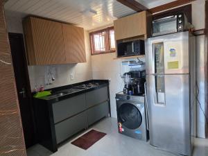 a kitchen with a stainless steel refrigerator and a stove at Varandas de Pirangi in Parnamirim