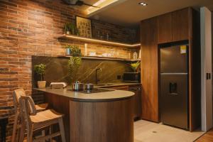 eine Küche mit einer Theke und einer Ziegelwand in der Unterkunft Hotel dieztreintayseis in Medellín