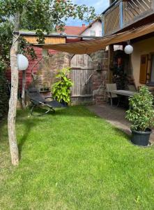 une cour arrière avec une pergola en bois et de l'herbe verte dans l'établissement Ferienwohnung Fuchsbau, à Weibersbrunn