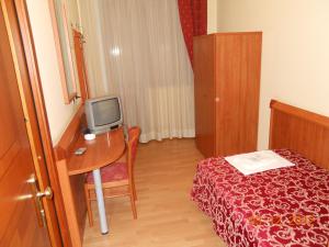 a room with a bed and a desk with a television at Hotel Val Di Sangro in Perano