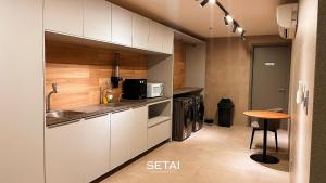 a kitchen with white cabinets and a table in it at Setai Aquamaris by Setai Apartaments in João Pessoa