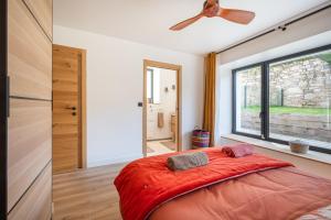 Un dormitorio con una gran cama roja y una ventana en Ar Pavilhon, en Douarnenez