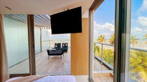 a bedroom with a flat screen tv on a balcony at Setai Aquamaris by Setai Apartaments in João Pessoa