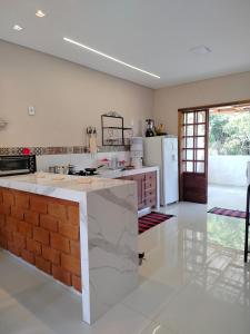 a kitchen with a brick counter and a refrigerator at Serra Santíssima - Refúgio perto do Centro Histórico in Tiradentes