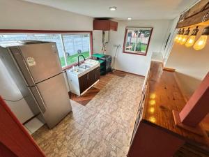 a kitchen with a stainless steel refrigerator and a sink at Cabañas fariña llanquihue in Llanquihue