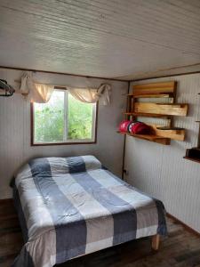 a bedroom with a bed and a window at Cabañas fariña llanquihue in Llanquihue