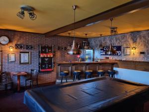 a bar with a large wooden table in a room at De Oude Bakkerij in Onderdendam