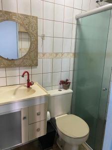 um banheiro com vaso sanitário, pia e espelho em Casa completa em cabo frio em Cabo Frio