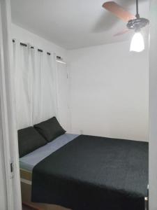 um quarto com uma cama e um ventilador de teto em Casa completa em cabo frio em Cabo Frio