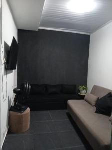 uma sala de estar com um sofá e uma televisão em Casa completa em cabo frio em Cabo Frio