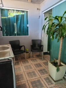 um banheiro com duas cadeiras e um vaso de planta em Casa completa em cabo frio em Cabo Frio