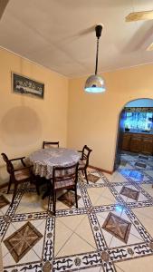 een eetkamer met een tafel en stoelen op een tegelvloer bij NR Investments in Kingstown