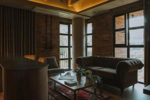 ein Wohnzimmer mit Sofa und Tisch in der Unterkunft Hotel dieztreintayseis in Medellín + 72 Fotos