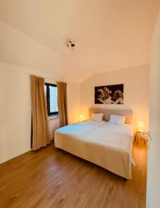 a bedroom with a large bed and a window at Secondo Piano Hasselt in Hasselt