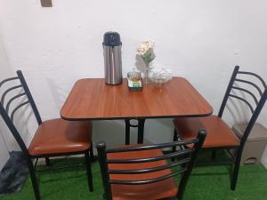 a table with a thermos and flowers on it at Apartment on the 1st Floor in Lima