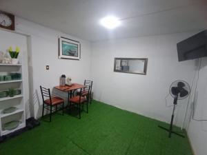 a room with a table and chairs and green carpet at Hospedaje - A y C Taxi- Airport - Accommodation in Lima