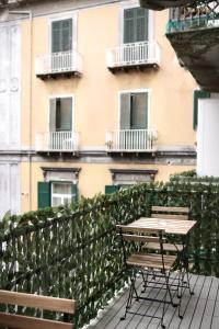 a table and chairs on a balcony in front of a building at Parthenope Luxury Apartment in Naples