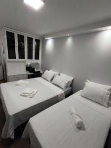 a bedroom with two beds with towels on them at Apartamento aconchegante na Asa Norte in Brasilia