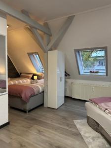 a attic bedroom with two beds and two windows at Oppiner Straße 14 Trotha4 in Halle an der Saale
