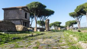 an ancient ruins with trees and a dirt road at Domus Appio Latino - Parco Appia Antica in Rome