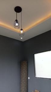 Deux lumières suspendues à un plafond avec une fenêtre dans l'établissement The Mandalika Rinjani Lombok, à Masbagik