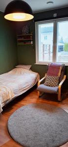 ein Schlafzimmer mit einem Bett, einem Stuhl und einem Teppich in der Unterkunft Villa near the sea in a scenic area in Mariehamn in Mariehamn