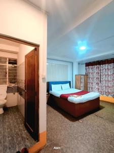 a bedroom with a bed and a toilet in it at Hotel Falcon View in Darjeeling