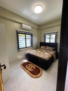 een slaapkamer met een bed en een tapijt bij Majestic Apartment 1 Tout lui Faut in Flora