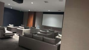 a lecture room with white chairs and a screen at Bonito doral in Miami +23 photos