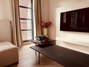a living room with a tv and a coffee table at Secondo Piano Hasselt in Hasselt +6 photos