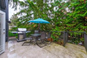 - une terrasse avec une table, un grill et un parasol dans l'établissement Cozy 3BR Family Home near City Centre & SkyTrain, à Coquitlam