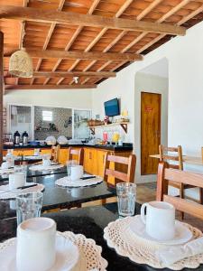 eine Küche mit einem Tisch mit weißem Geschirr darauf in der Unterkunft Pousada Zoom Jericoacoara in Jericoacoara