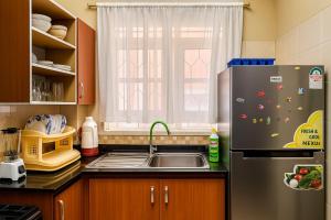 a kitchen with a sink and a refrigerator at Bonaventure Apartment A in Kisumu