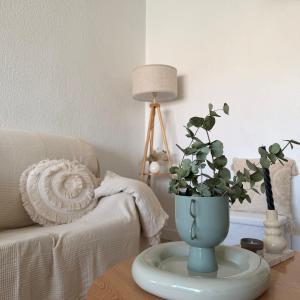 a blue vase on a table with a potted plant at Piso en el corazon de Las Torres de Cotillas in Las Torres de Cotillas