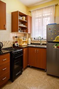 a kitchen with wooden cabinets and a black refrigerator at Bonaventure Apartment A in Kisumu