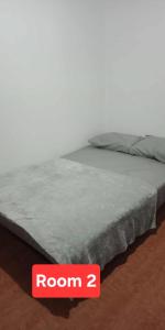 un lit avec un panneau de chambre à côté dans l'établissement Auntie's, à Tanza