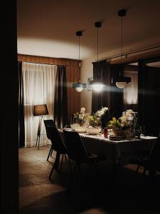 a dining room with a table with chairs and lights at Brīvdienu māja & pirts meža vidū - Saraiķu Sanderi in Saraiķi