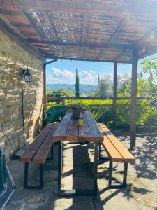a wooden picnic table sitting under a pergola at Agriturismo Montesalce in Gubbio