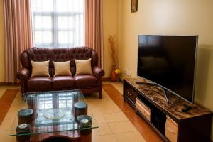 a living room with a couch and a flat screen tv at Bonaventure Apartment A in Kisumu
