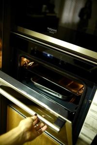 a person is taking something out of an oven at Parthenope Luxury Apartment in Naples
