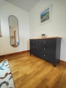 a bedroom with a dresser and a mirror at Hillside Park Studio in Easter Quarff